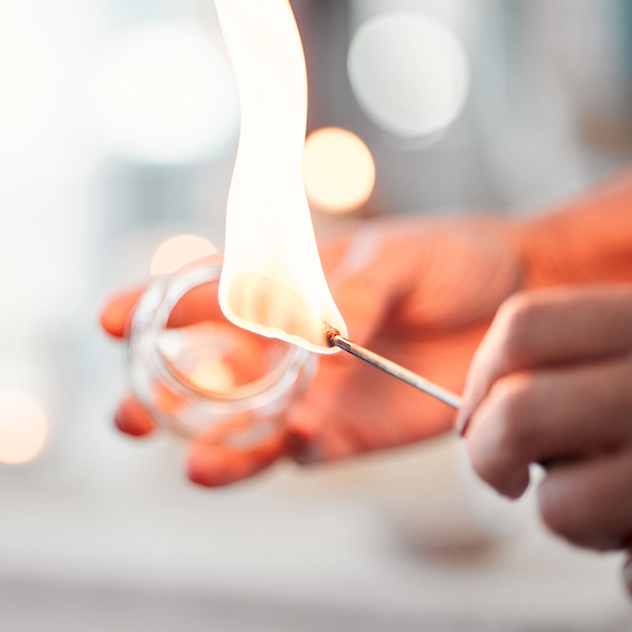 Ein Schröpfglas wird mit einer Flamme erhitzt